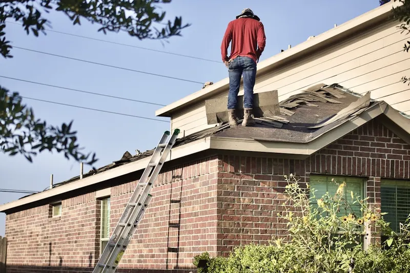 Professional roofer working on a residential roof in Petroleum